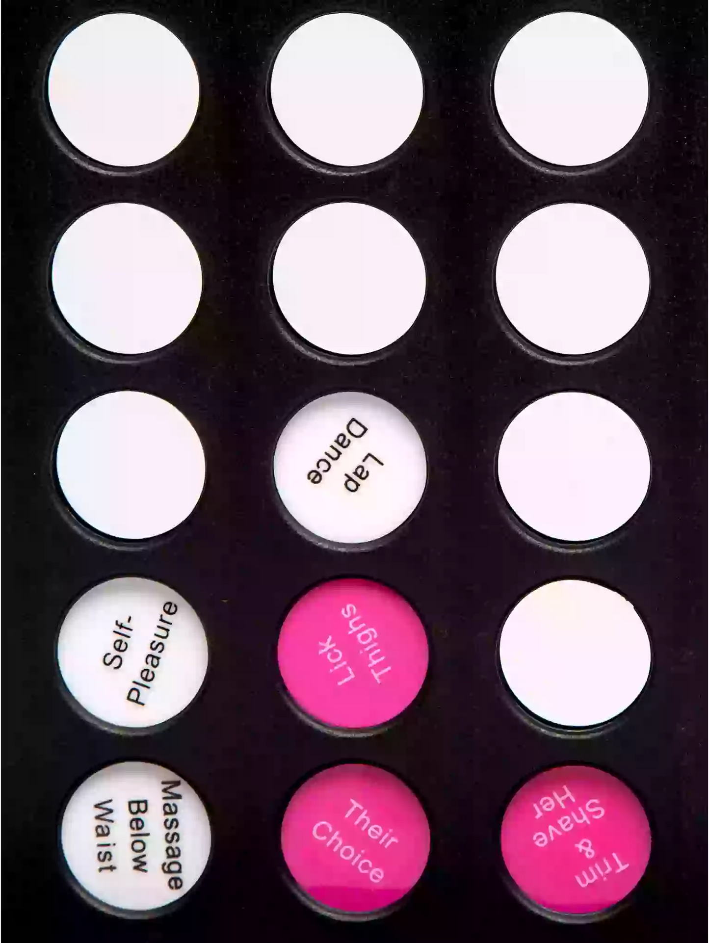 Black board with white and pink buttons labeled with various phrases.