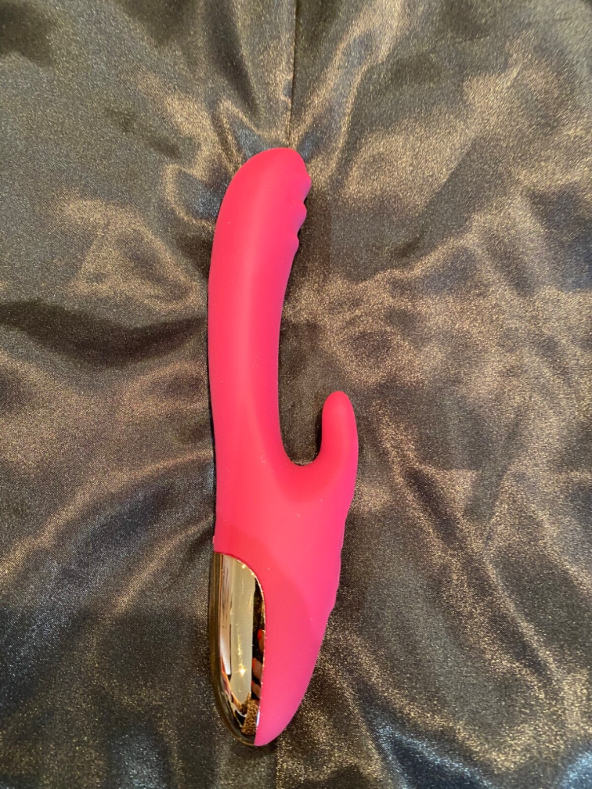 Pink and gold异性用品 on a gray fabric background