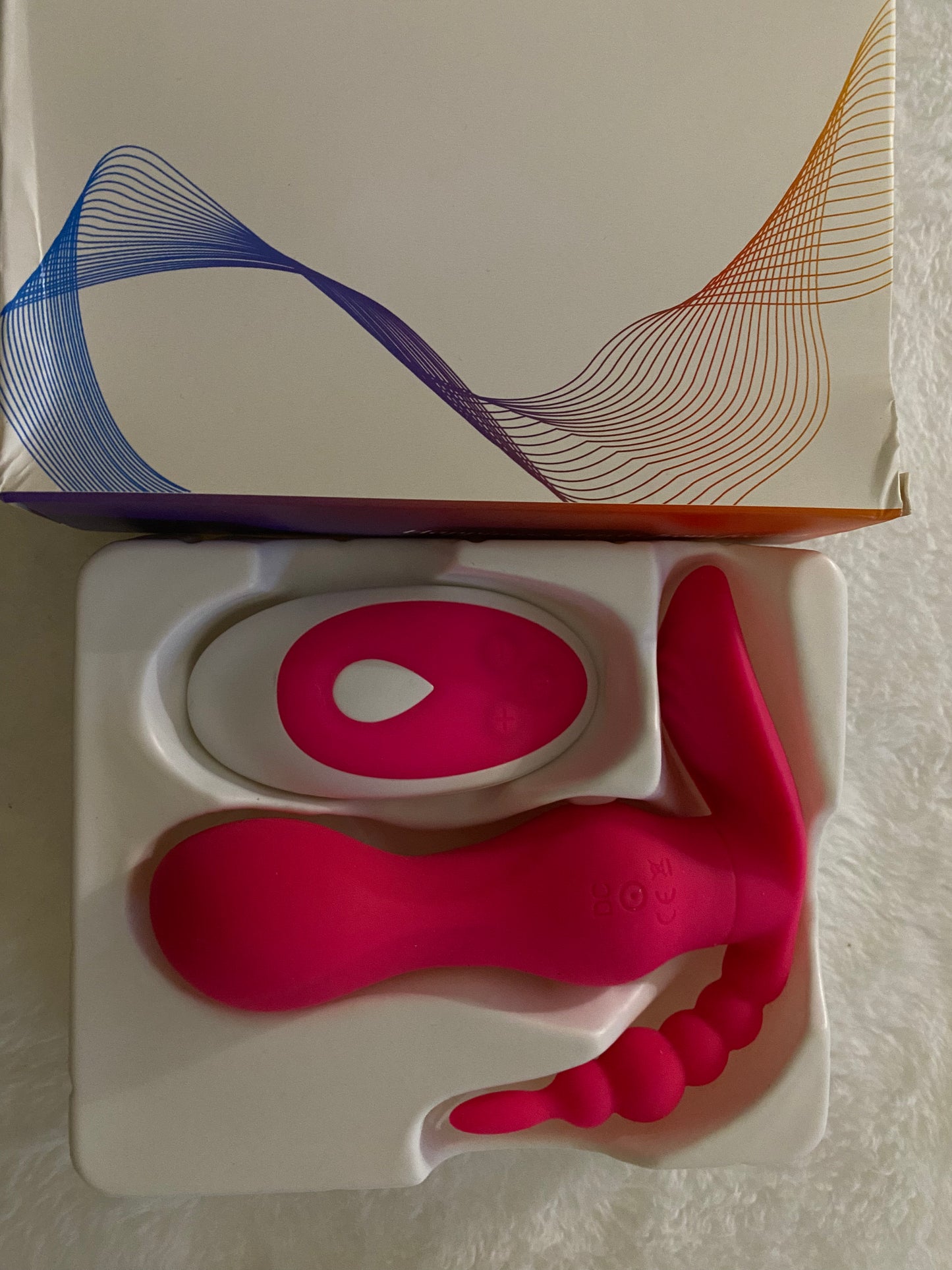 Pink silicone tool on a white stand with a branded box in the background