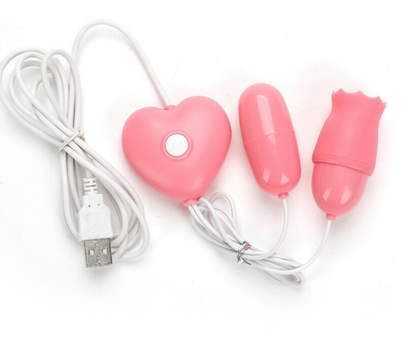 Pink heart-shaped device with two attachments and a USB cable on a white background