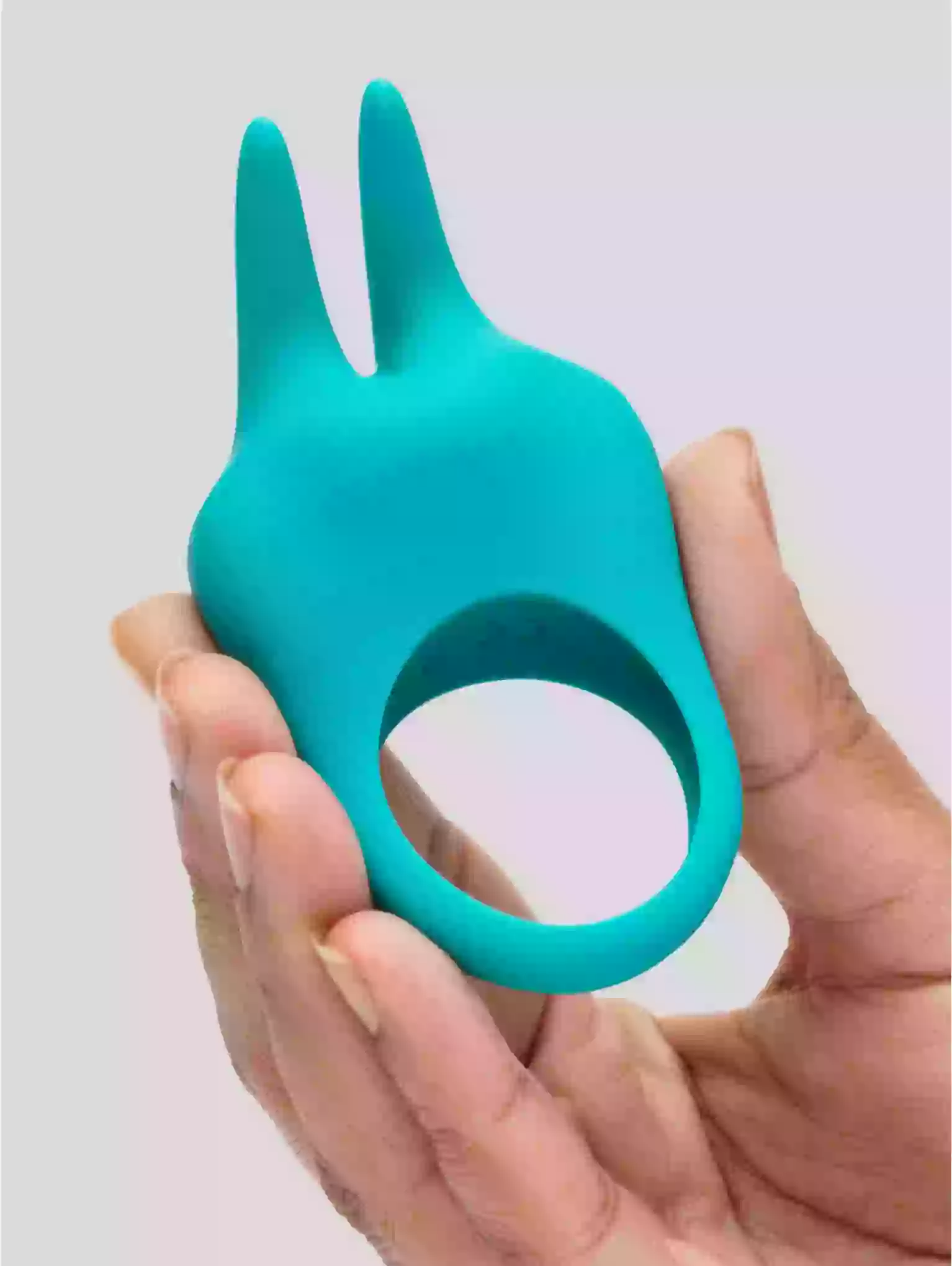 Turquoise tool with a unique design held in a hand against a light background