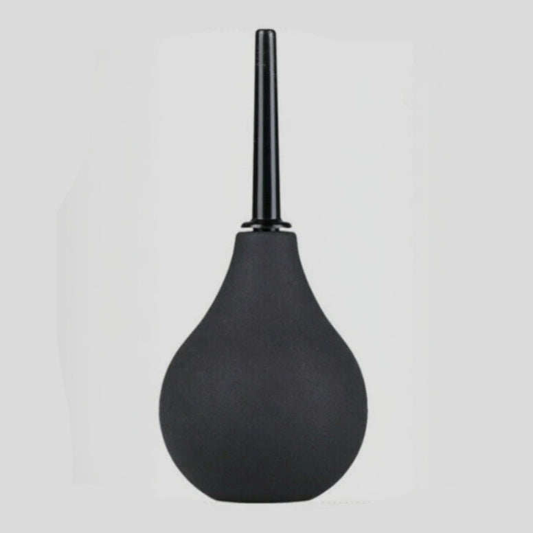 Black rubber bulb syringe on a light gray background