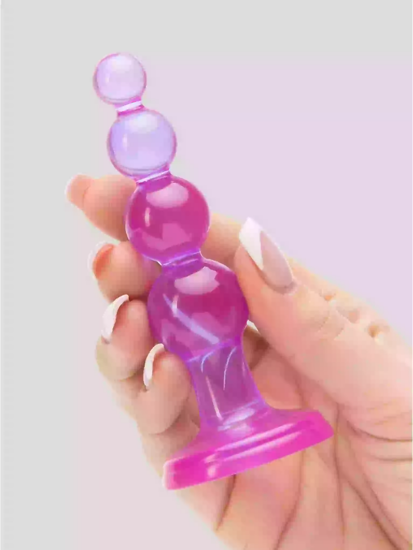 Hand holding a pink and purple silicone product against a light gray background