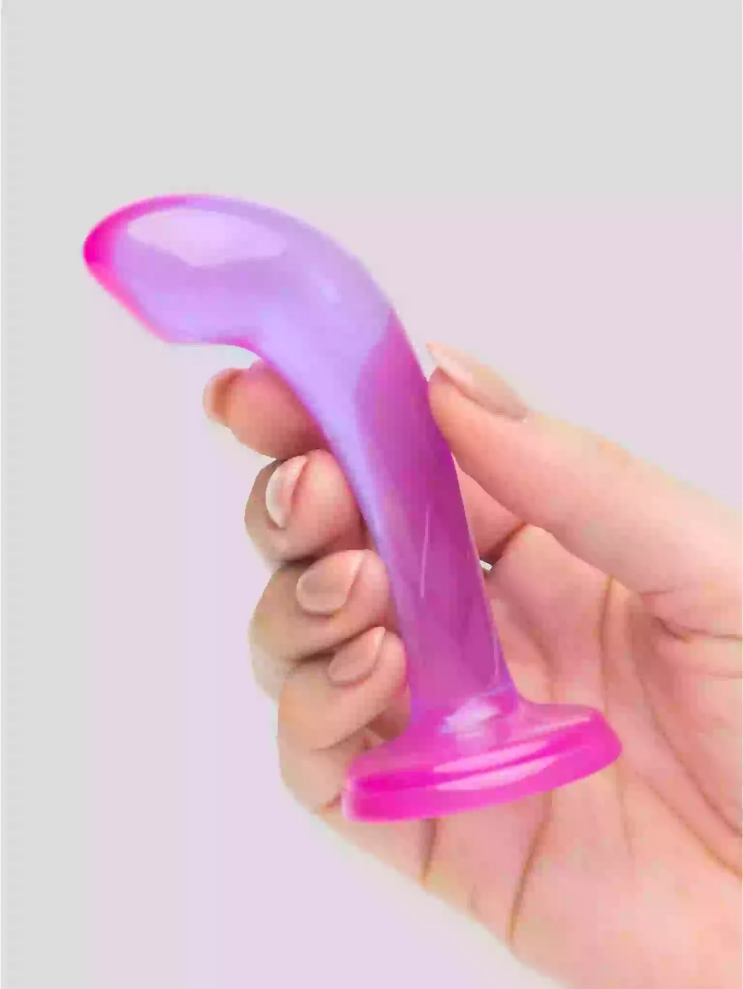 Hand holding a purple and pink silicone object against a light gray background
