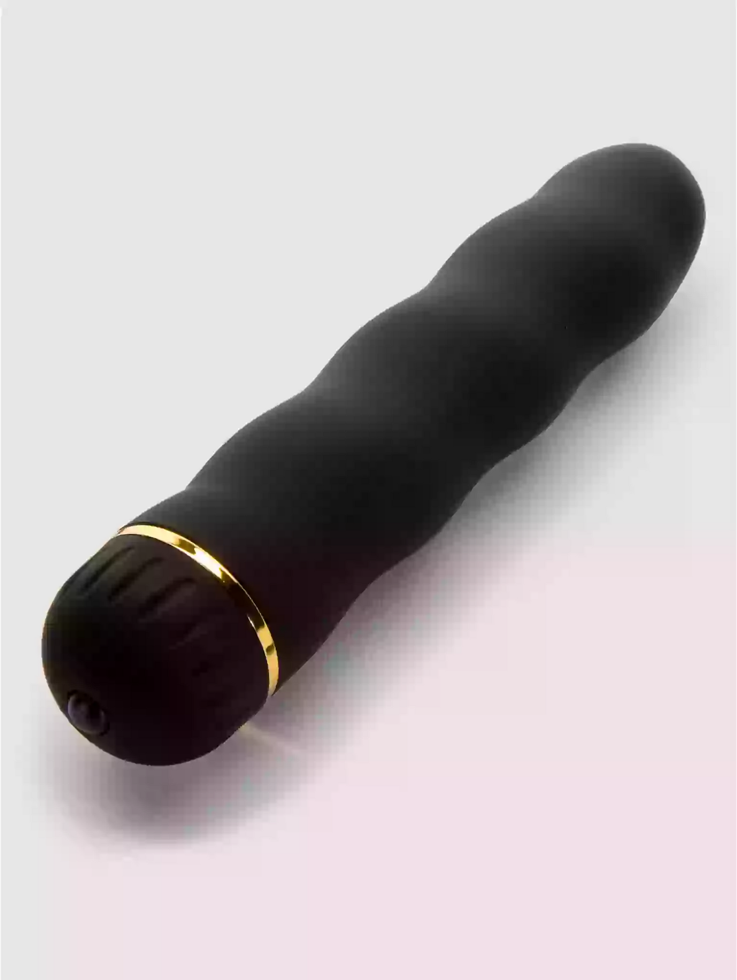 Black and gold cylindrical object on a light gray background
