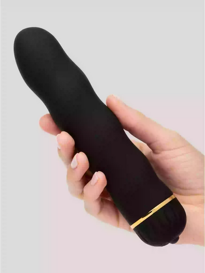 Black and gold electronic device held in a hand against a light gray background
