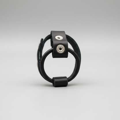 Black leather bracelet with metal clasps on a gray background