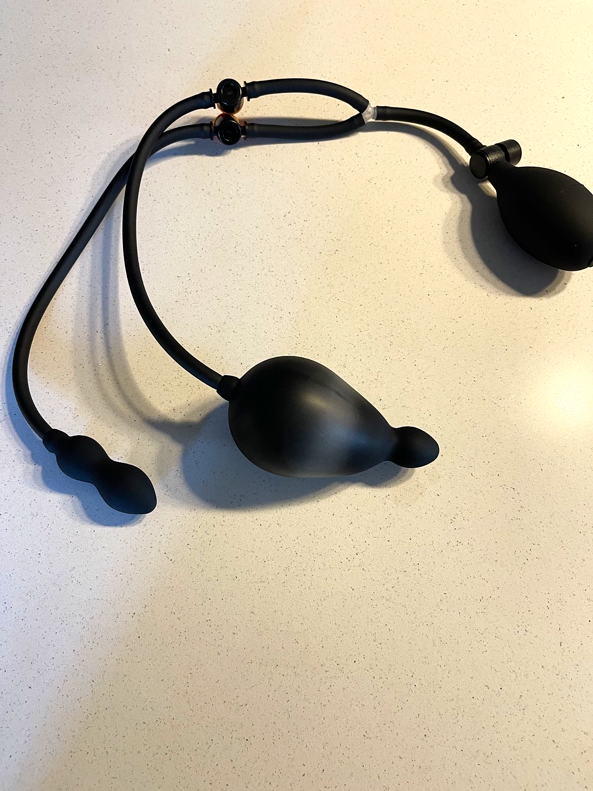 Black rubber band with spherical ends on a light beige background