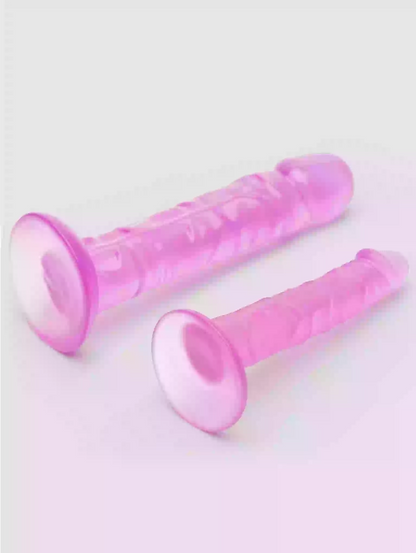 Two pink silicone dildos on a light gray background