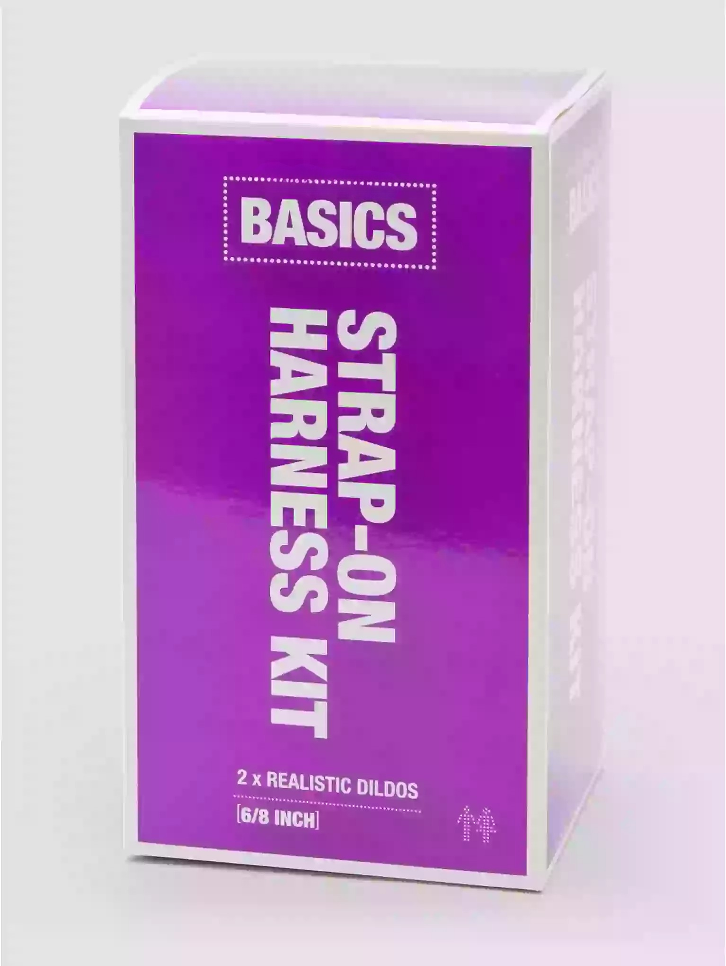 Purple packaging of a 'Basics' strap-on harness kit on a white background