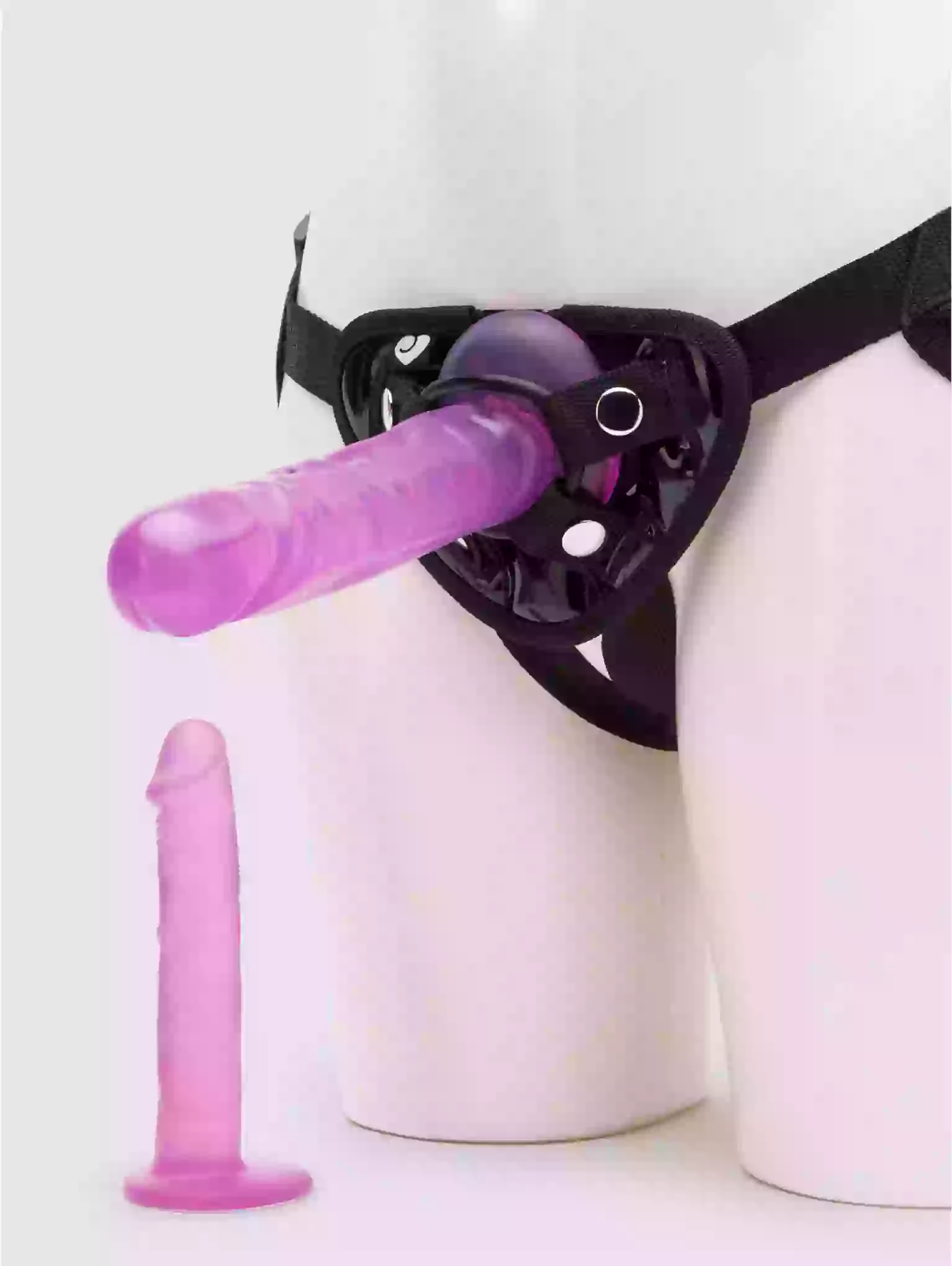 Purple object attached to a black harness on a white background