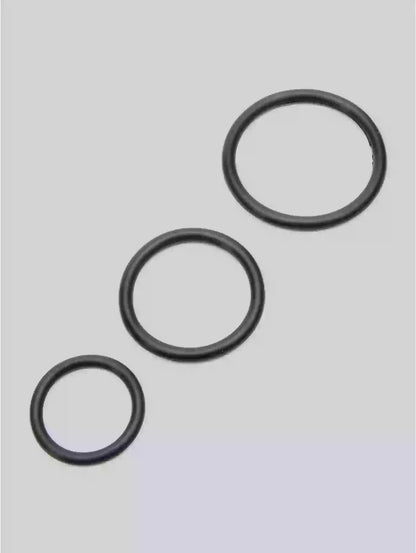 Three black rubber o-rings on a light gray background