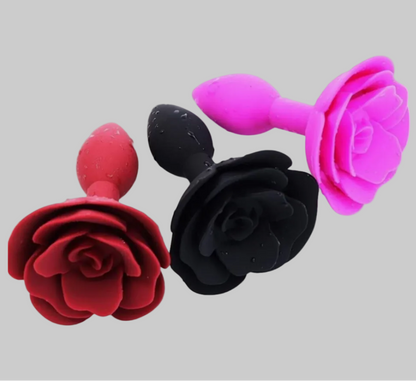 Three floral-shaped objects in red, black, and pink on a gray background