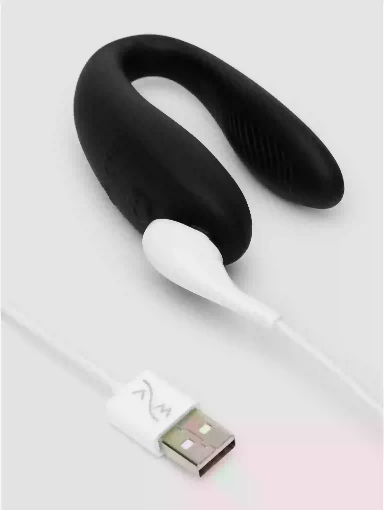 Black silicone ring with white USB cable on a light gray background