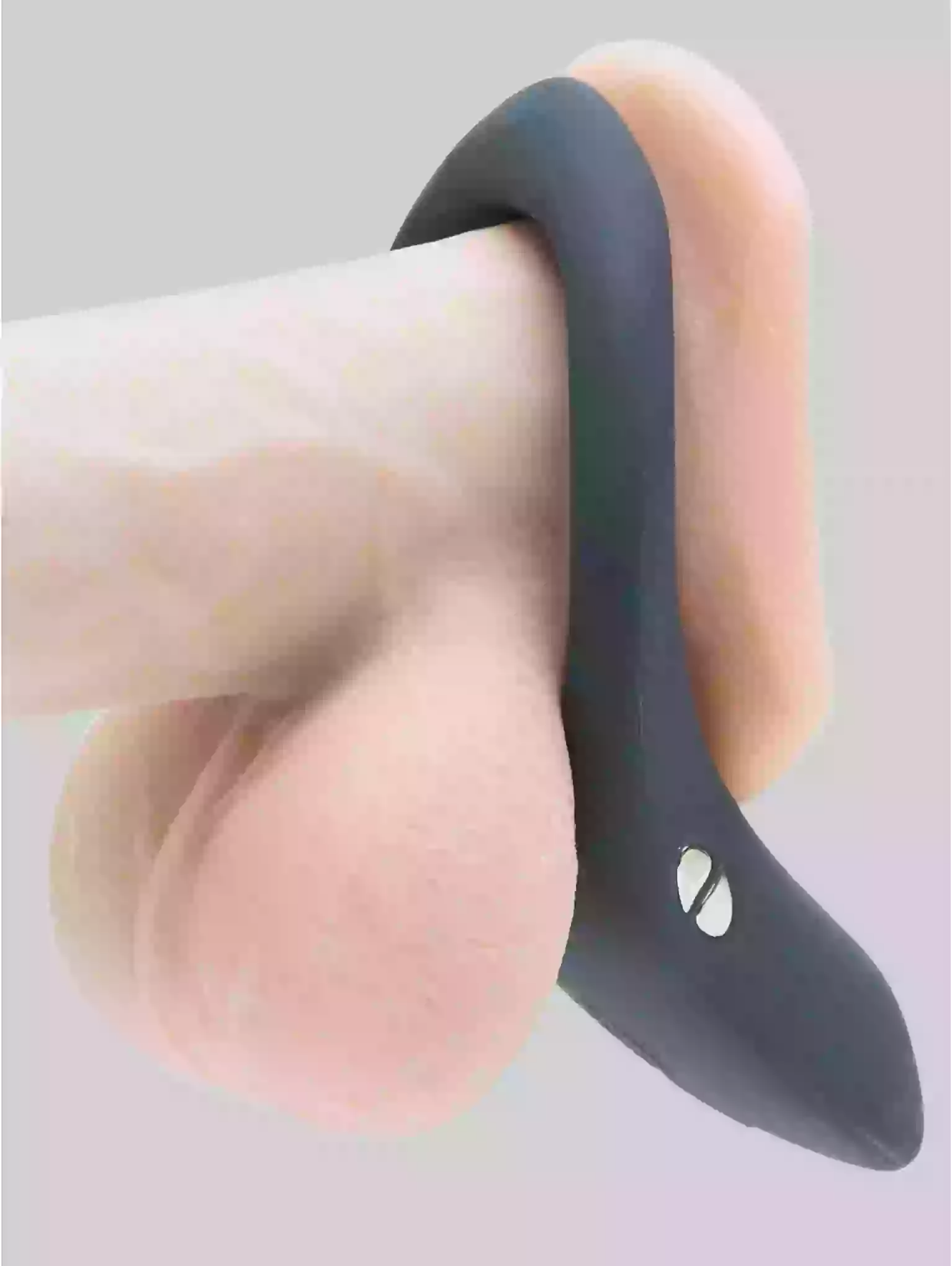 Black silicone ring on a finger against a light gray background