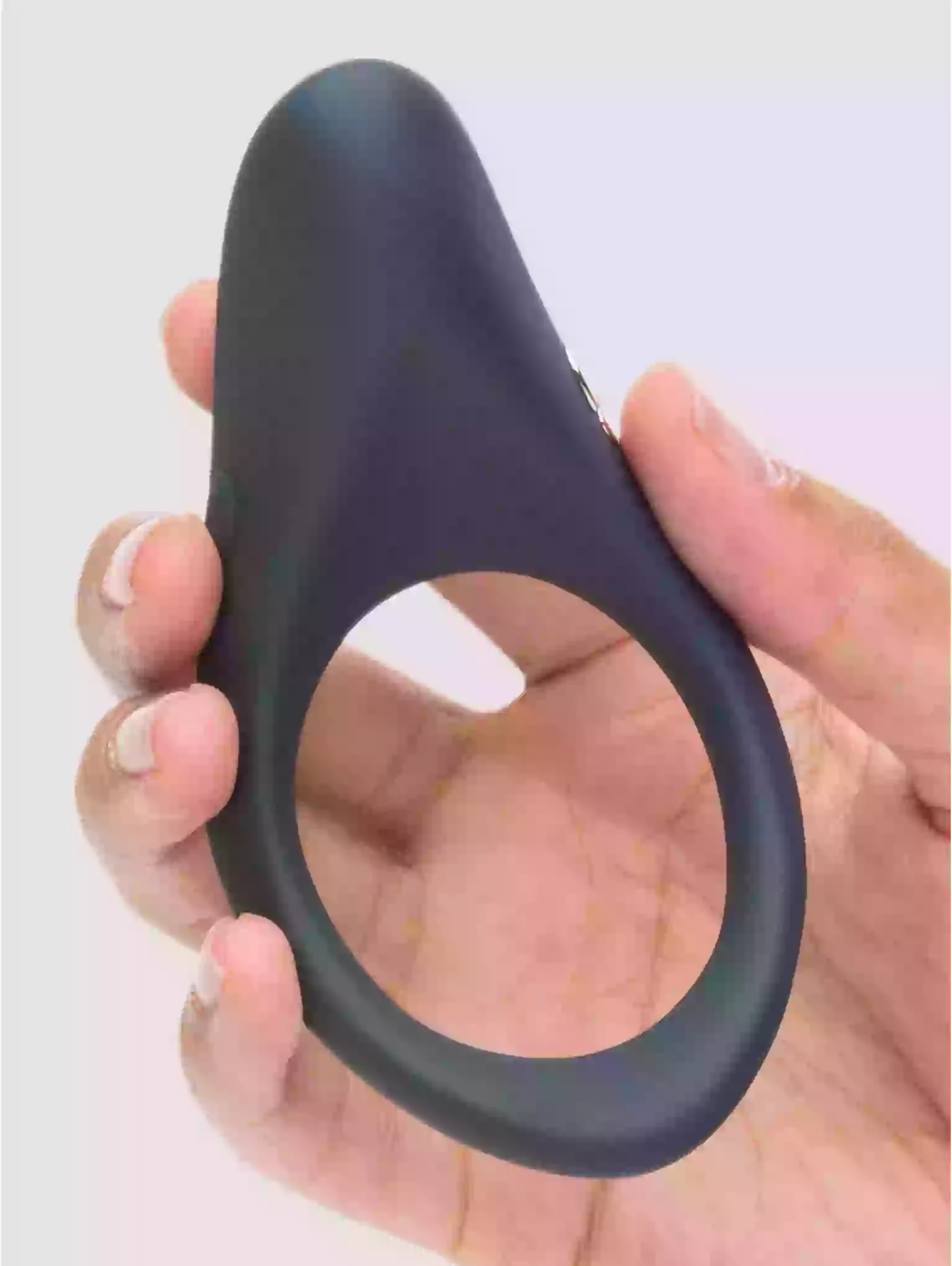 Black silicone ring held in a hand against a light background