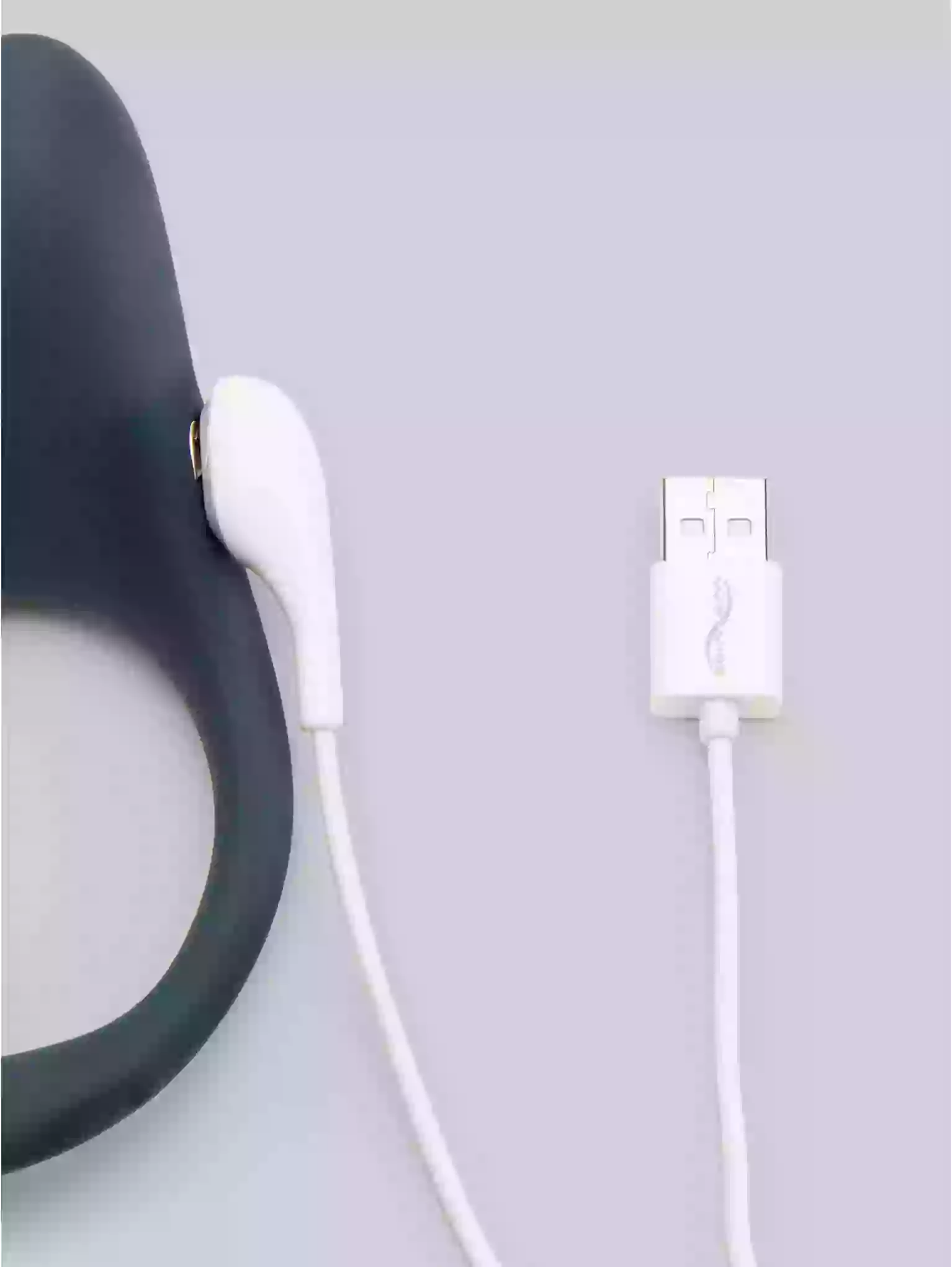 Black earbud and white charging cable on a light gray background