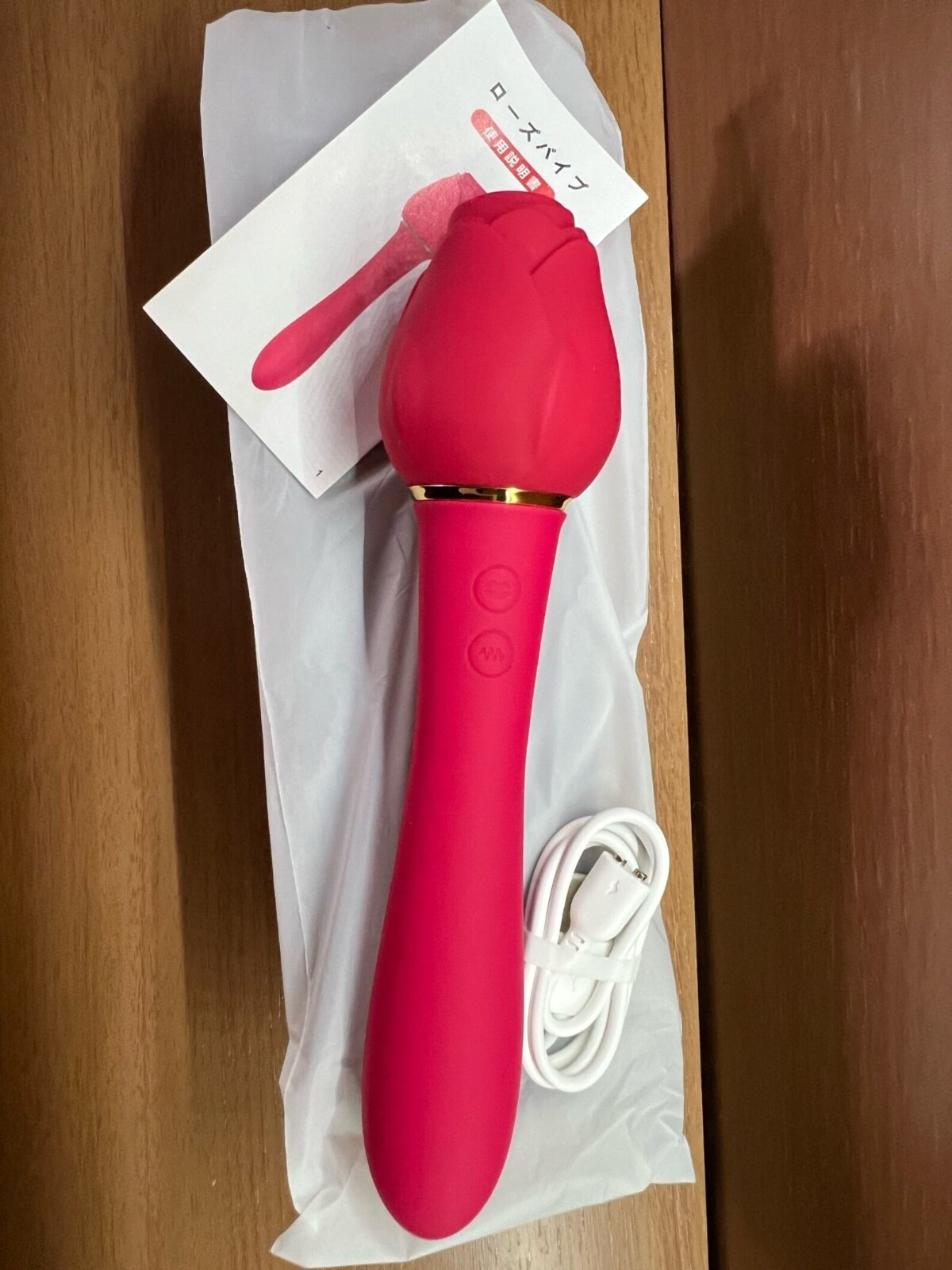 Red electronic device with gold accents on a wooden surface