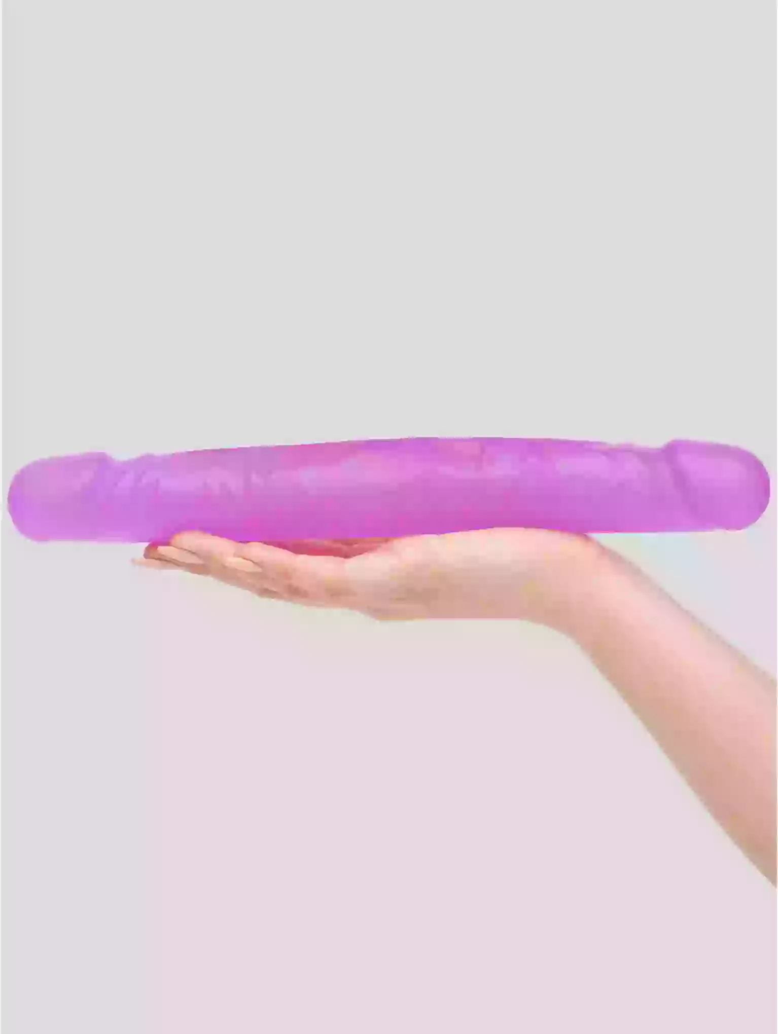 Purple stress ball held in a hand against a light purple background