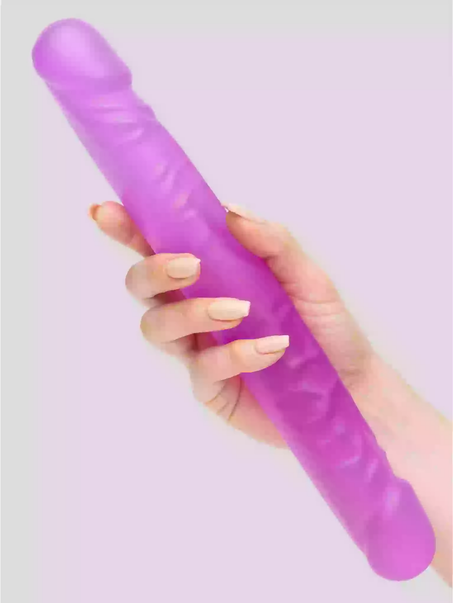 Hand holding a purple object against a light purple background