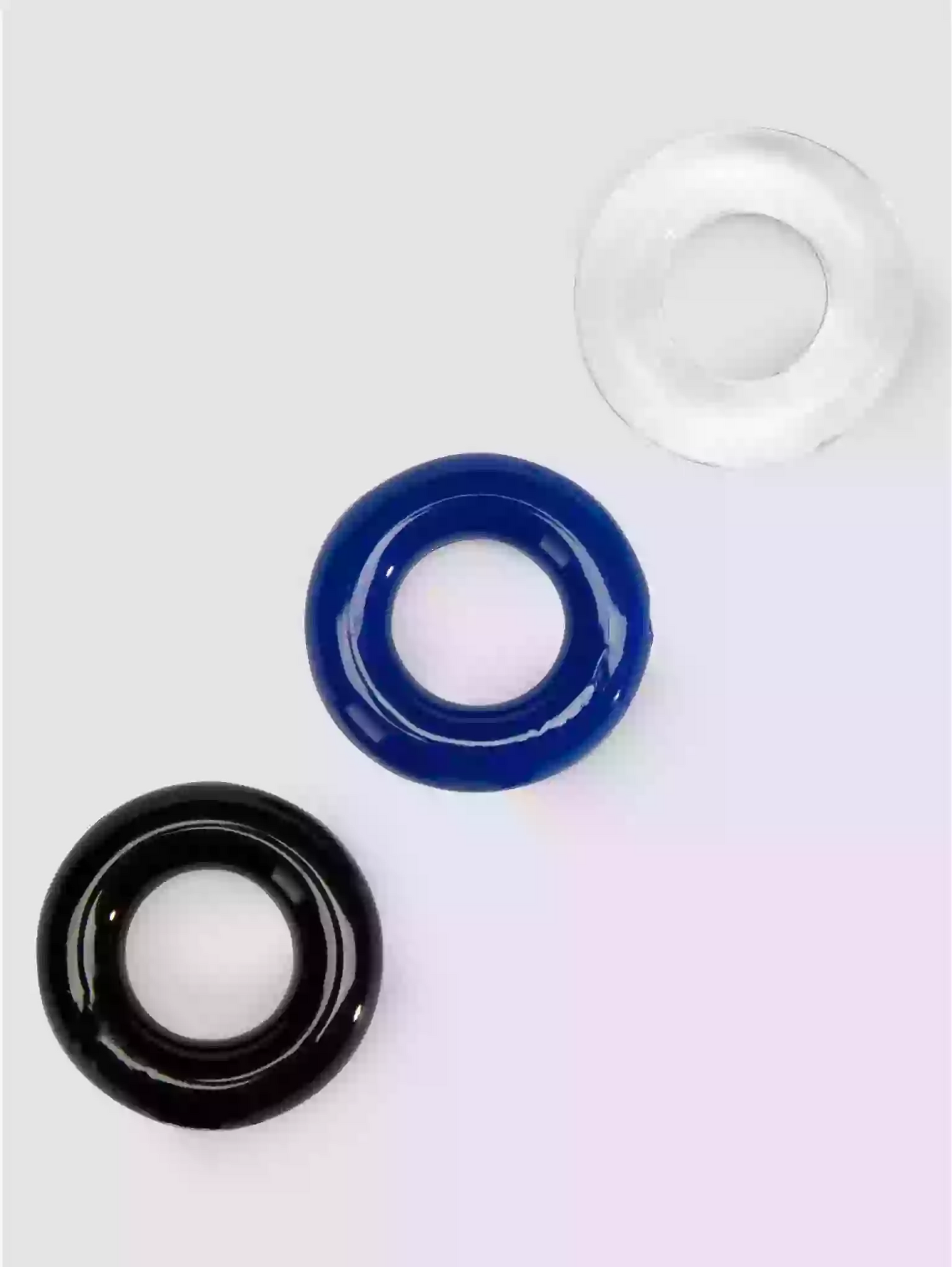 Three circular objects in black, blue, and clear on a white background