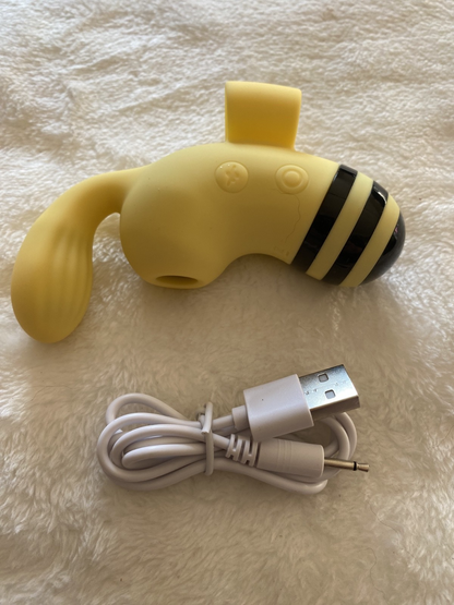 Yellow dog-shaped toy with USB cable on a textured surface
