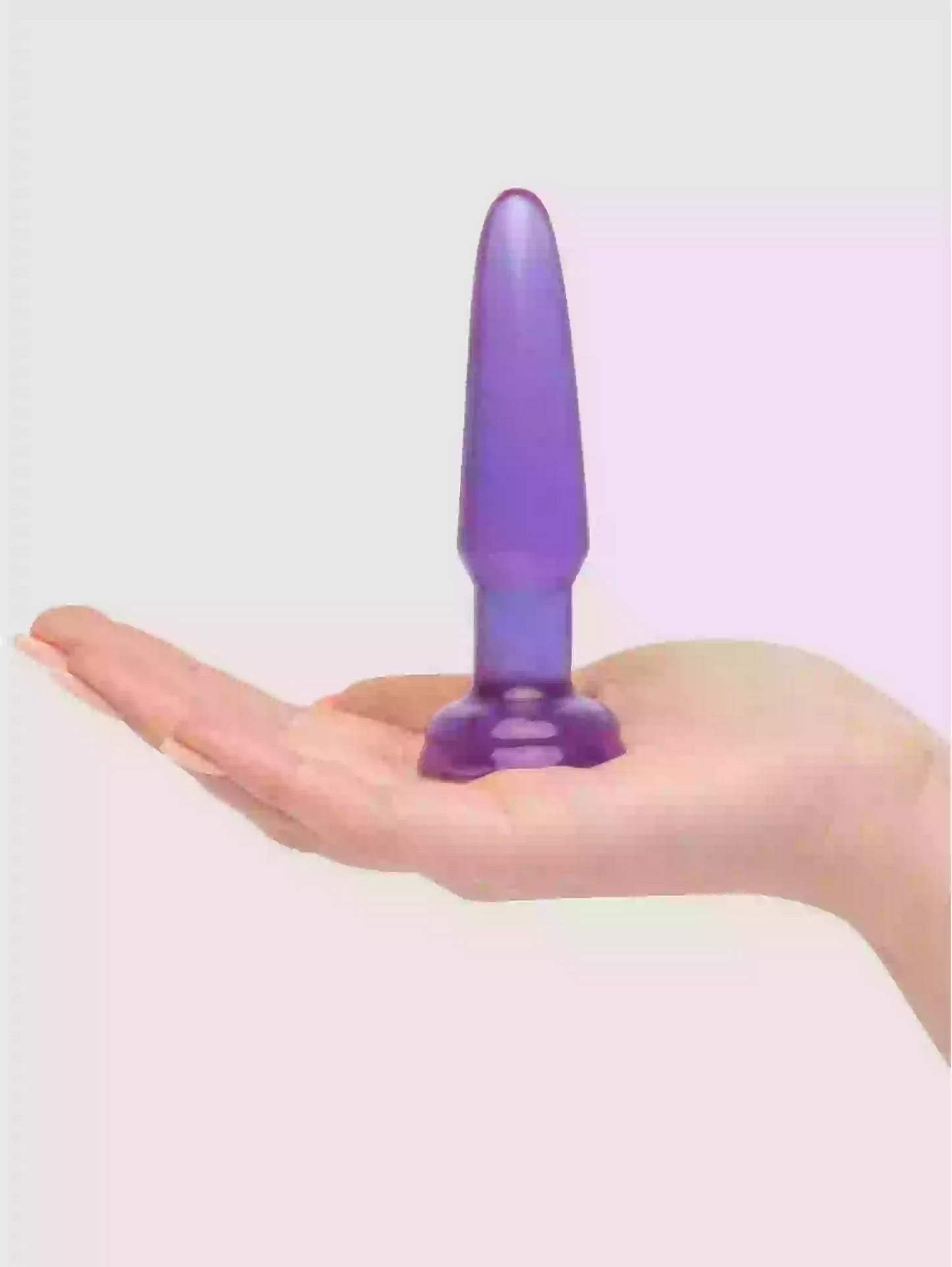 Purple cylindrical object held in a hand against a light background