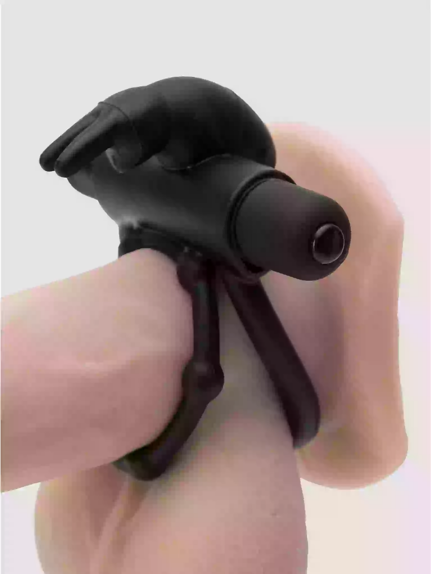 Black plastic tool held by a hand on a light gray background