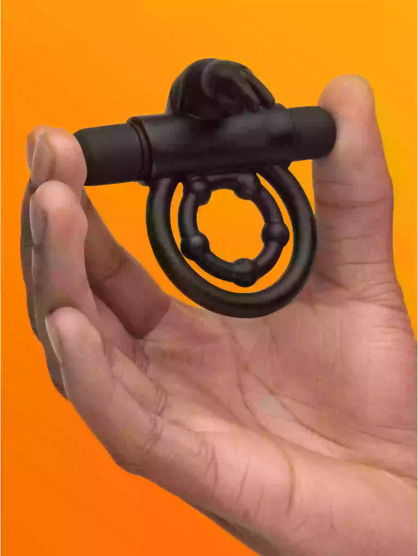 Black ring-shaped object held in a hand against an orange background