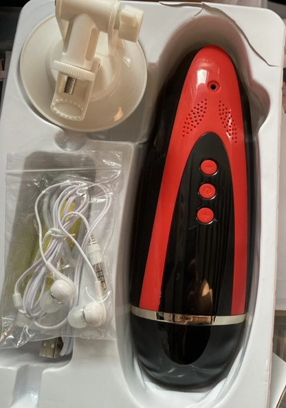 Black and red electronic device with earbuds and charging cable on a white surface