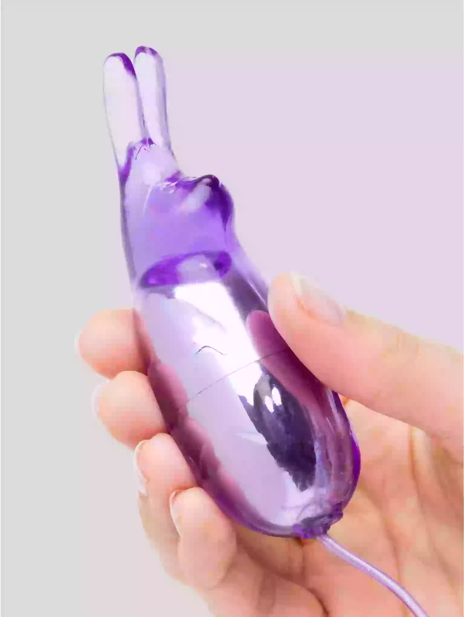 Purple electronic device held in a hand against a light gray background