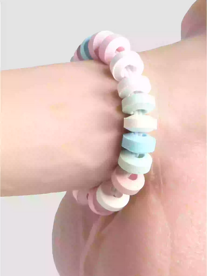 Pastel-colored beaded bracelet on a wrist against a light background