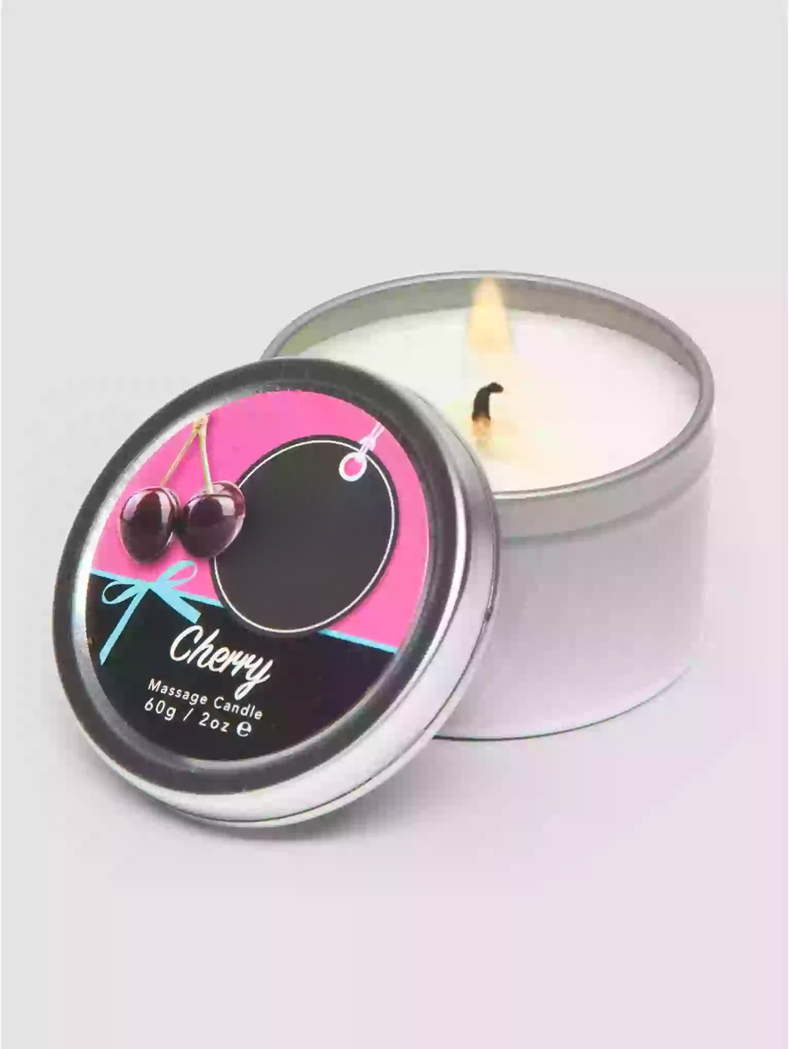 Candle in a tin with a cherry design on the label, on a light gray background