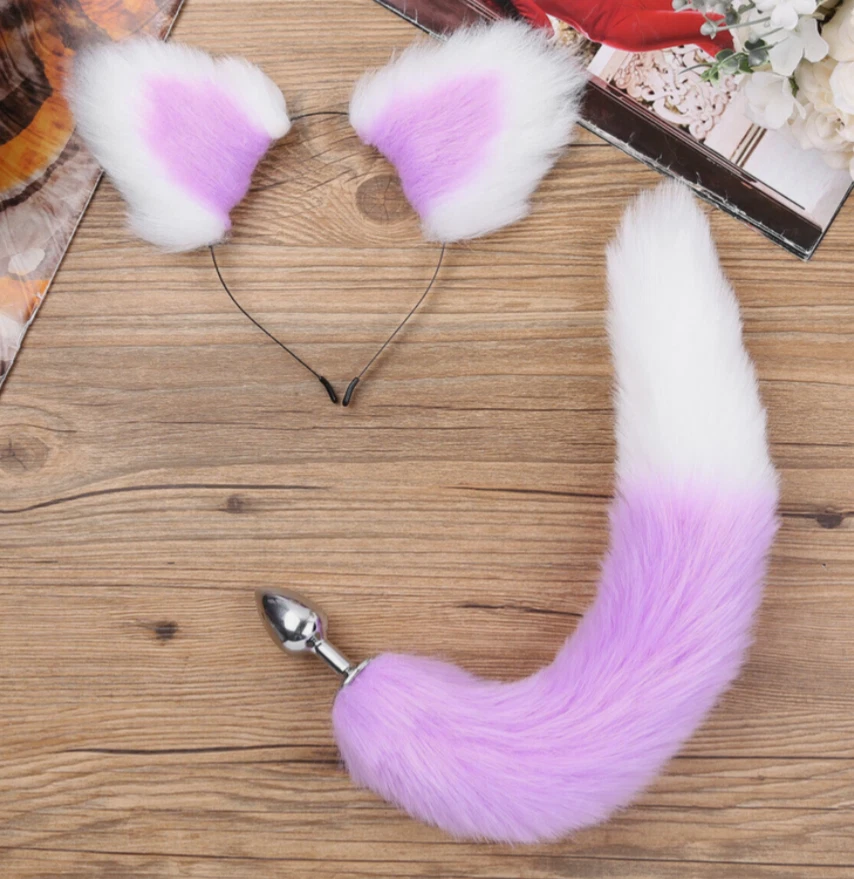 Pink fox tail with white tips on a wooden surface