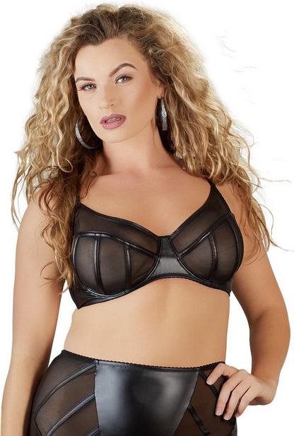 Woman wearing a black sheer bra and black pants on a white background
