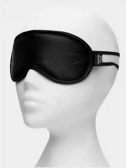 Black sleep mask on a mannequin head with a white background