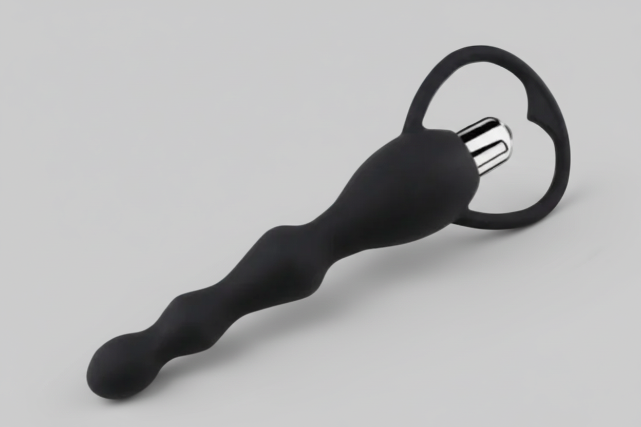 Black massage tool with circular head on a gray background