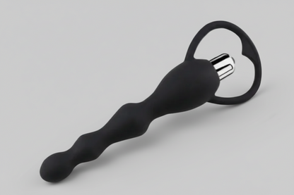 Black massage tool with circular head on a gray background