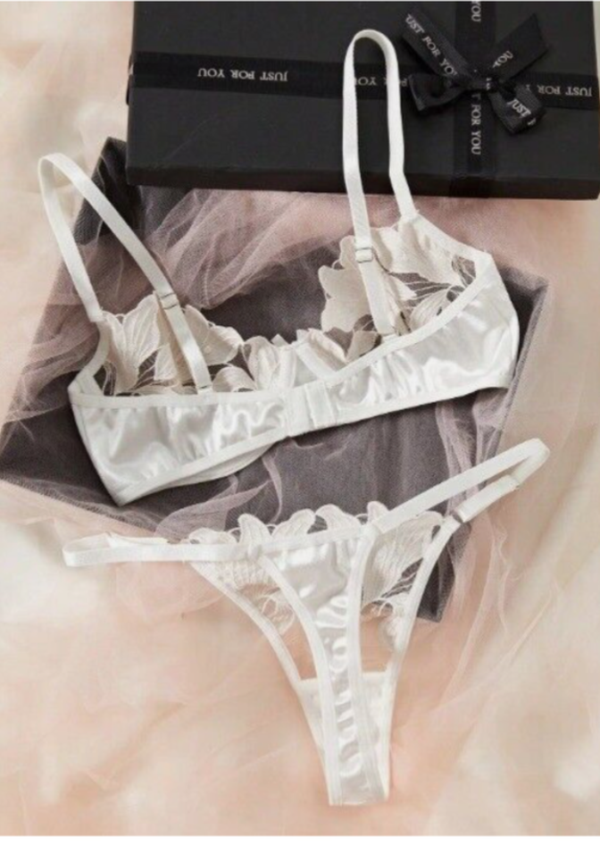 Woman wearing white lace lingerie against a gray background