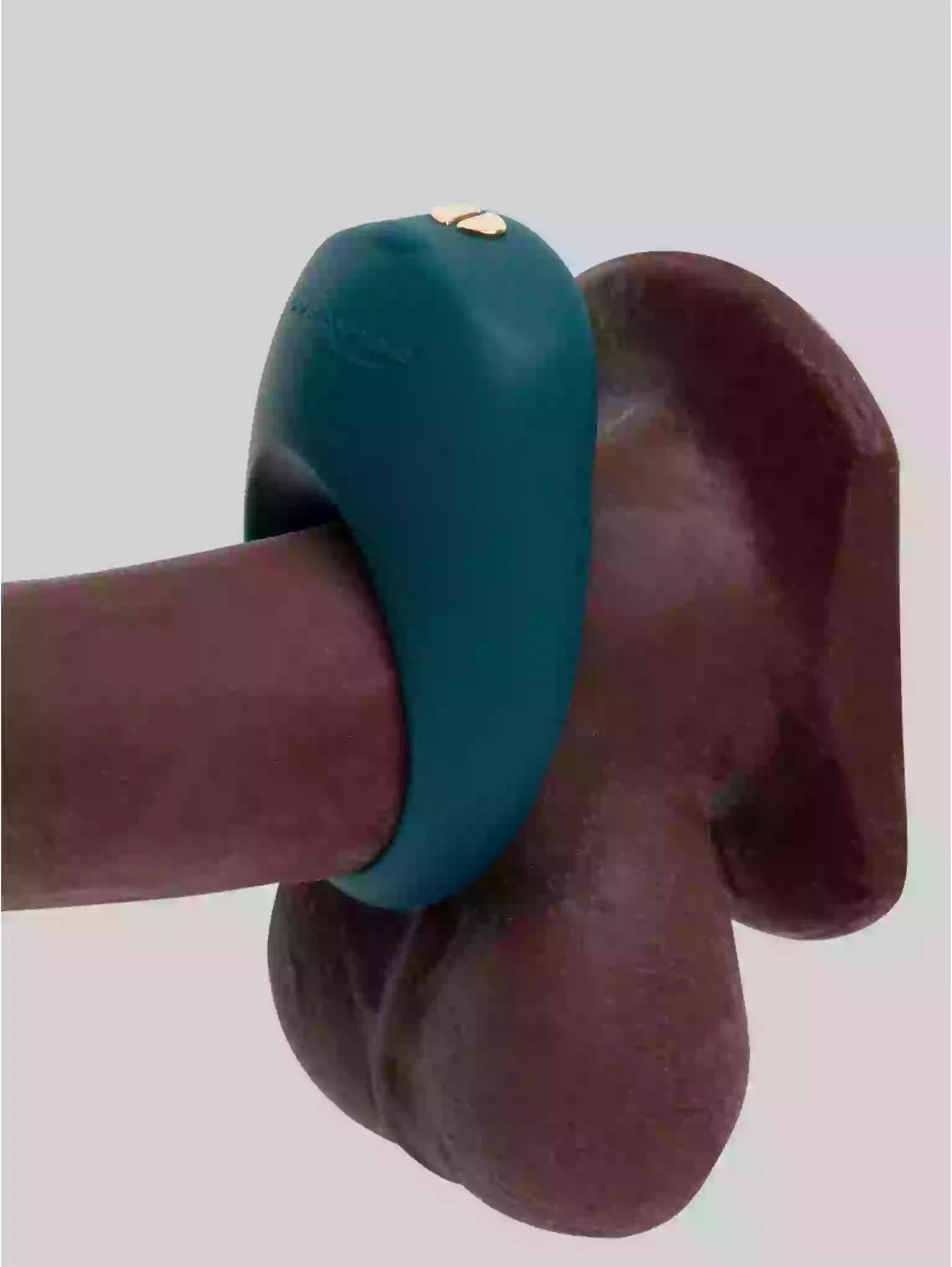 Teal ring on a wooden object against a light gray background