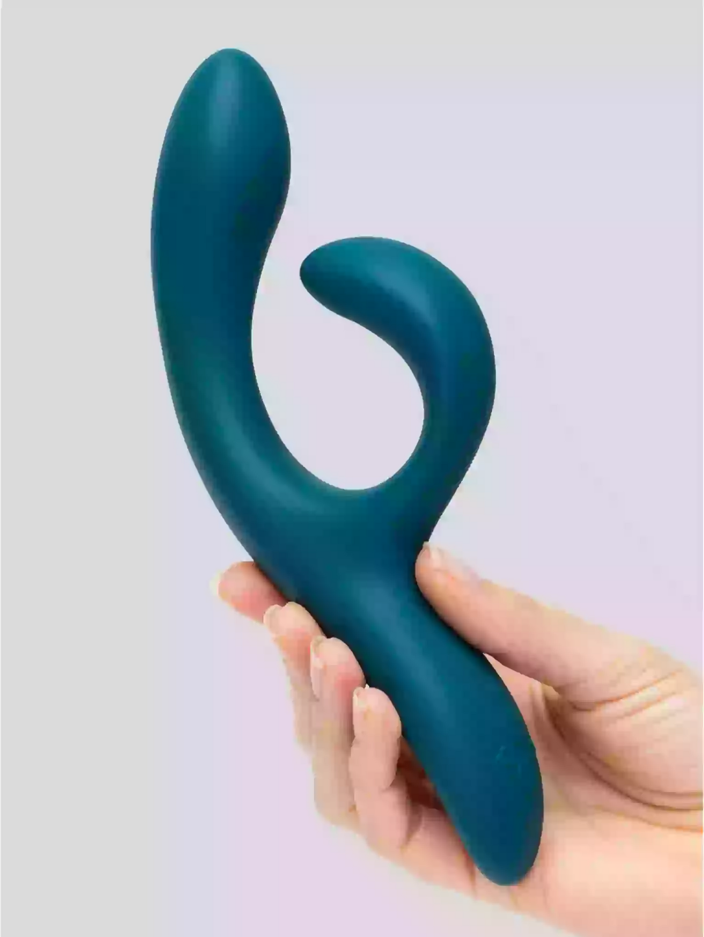 Blue silicone tool held in a hand against a light purple background