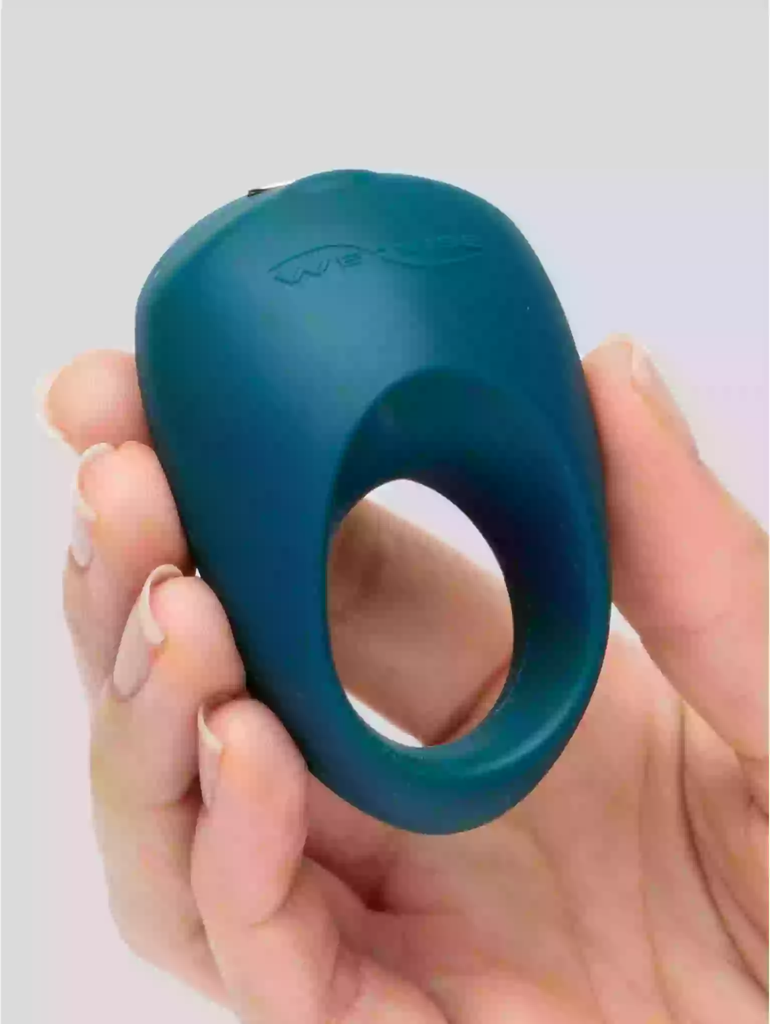 Blue silicone ring held in a hand against a light gray background