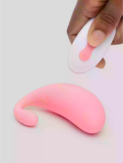 Pink and white silicone tool held by a hand on a light gray background