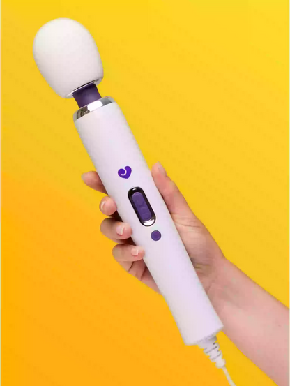 Hand holding a white and purple electronic device against a yellow background