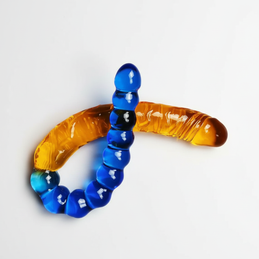 Glass worm-shaped object with blue and amber colors on a white background