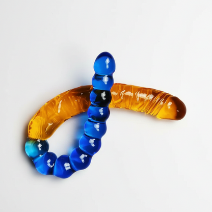 Glass worm-shaped object with blue and amber colors on a white background