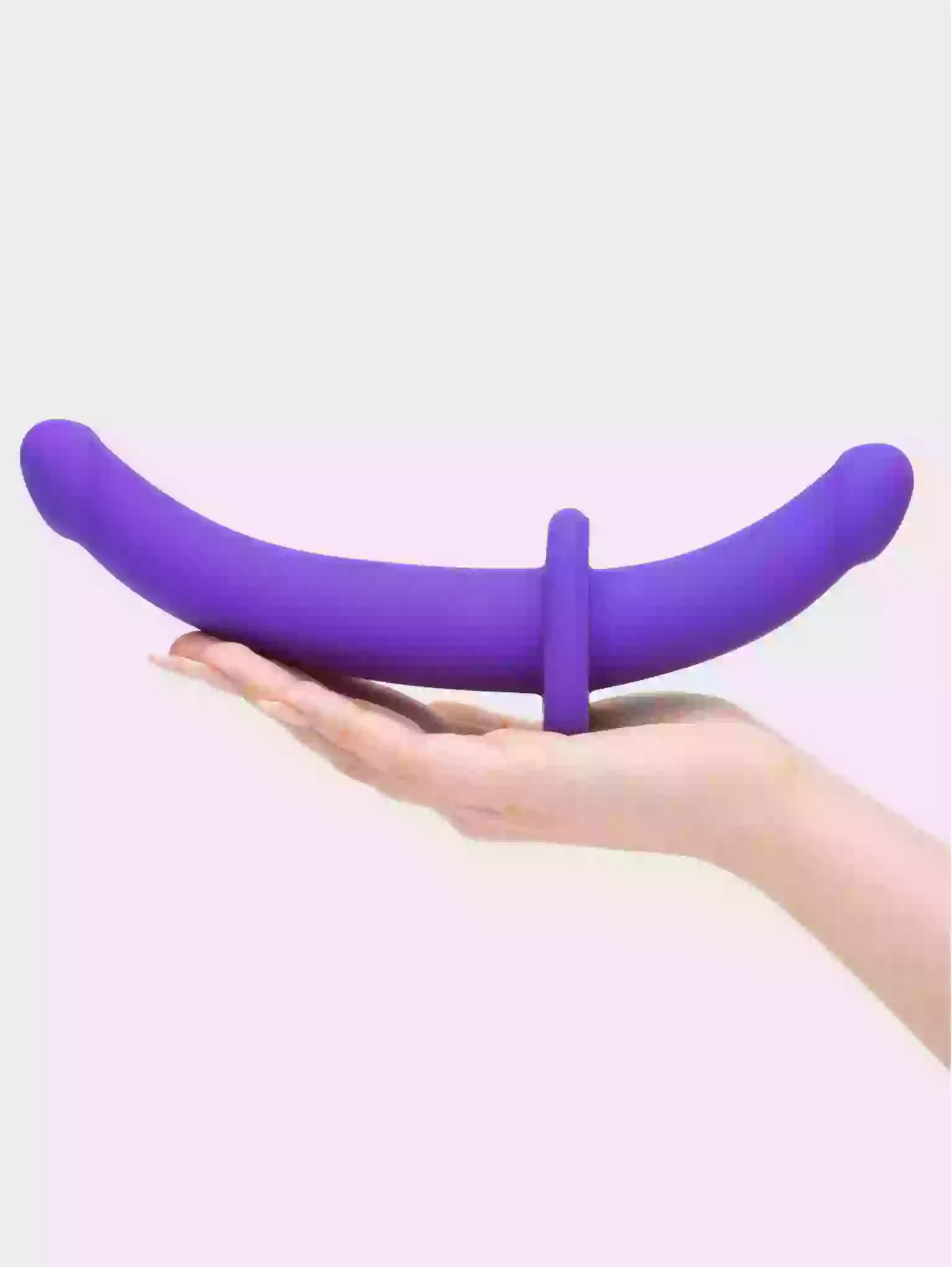 Purple silicone ring held in a hand against a light background