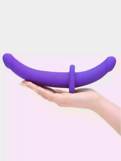 Purple silicone ring held in a hand against a light background