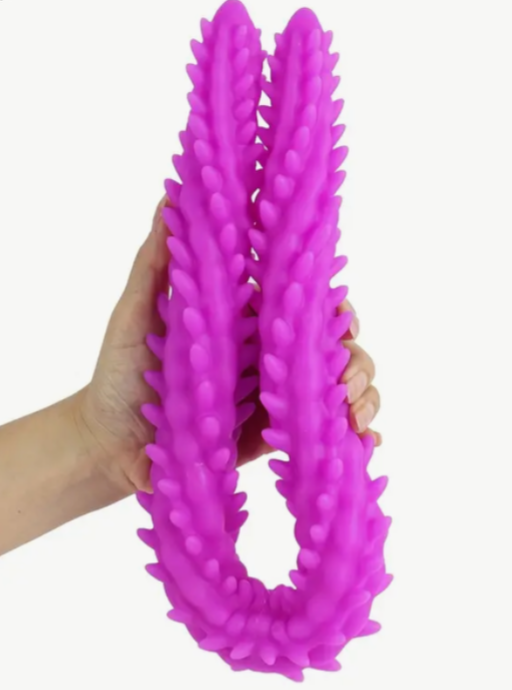 Purple textured ring held by a hand against a white background