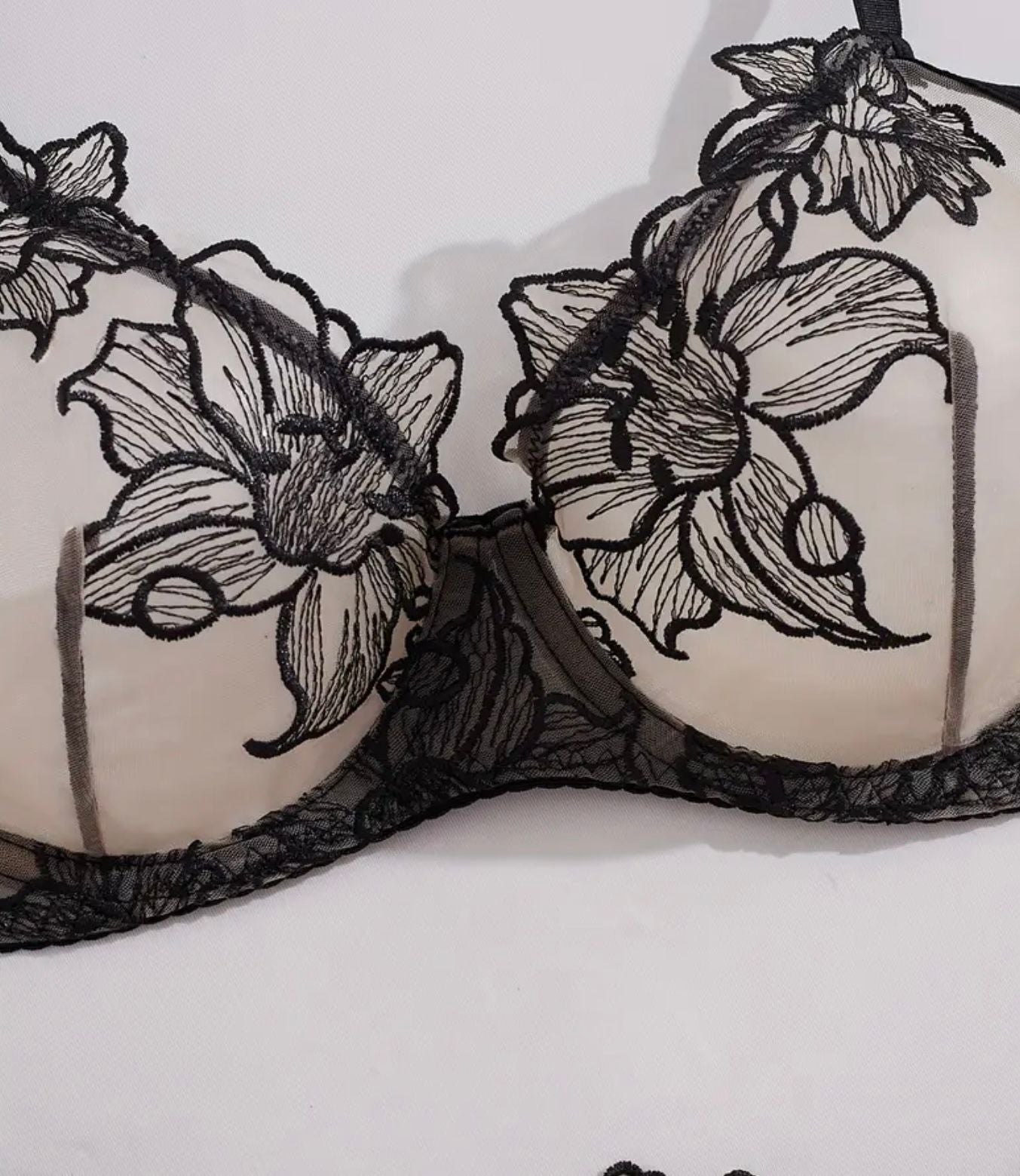 Black lace bra with floral designs on a white background